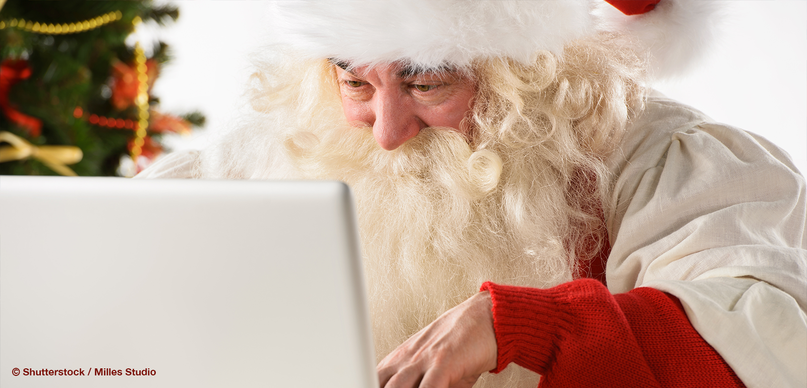 Weihnachtsmann am Laptop der grade etwas auf Social Media postet.